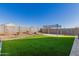 This backyard features a small, well-manicured lawn, paved patio, and pergola, perfect for outdoor entertainment at 3481 N 309Th Ln, Buckeye, AZ 85396
