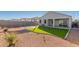 The home features a tidy backyard with artificial turf, a pergola, a paved patio, and well-kept landscape at 3481 N 309Th Ln, Buckeye, AZ 85396
