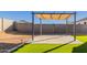 This backyard showcases a paved patio area with a pergola, perfect for outdoor seating and enjoying the manicured lawn at 3481 N 309Th Ln, Buckeye, AZ 85396