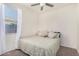 Cozy bedroom featuring carpeted floors, a ceiling fan, and a large window at 3481 N 309Th Ln, Buckeye, AZ 85396