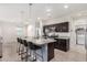 Bright kitchen features an island with bar seating, granite countertops, dark cabinetry, and stainless steel appliances at 3481 N 309Th Ln, Buckeye, AZ 85396
