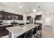 Spacious kitchen with granite countertops, stainless steel appliances, dark cabinetry, and a large center island with barstool seating at 3481 N 309Th Ln, Buckeye, AZ 85396