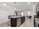 Bright kitchen featuring a large island with barstool seating, granite countertops, and stainless steel appliances at 3481 N 309Th Ln, Buckeye, AZ 85396