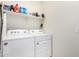 Bright laundry room with a Whirlpool washer and dryer, with built-in shelving for storage at 3481 N 309Th Ln, Buckeye, AZ 85396