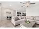 Comfortable living room with a large sectional sofa, modern coffee table, and views into the kitchen and dining area at 3481 N 309Th Ln, Buckeye, AZ 85396
