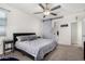 This main bedroom features a ceiling fan, a barn door to the ensuite, and neutral decor at 3481 N 309Th Ln, Buckeye, AZ 85396