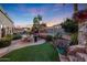 Landscaped backyard with a pool, patio furniture, and artificial turf at 4808 N Litchfield E Knl, Litchfield Park, AZ 85340