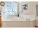 Relaxing bathroom with a large corner bathtub and a glass block window at 4808 N Litchfield E Knl, Litchfield Park, AZ 85340