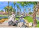 Scenic community view with lush landscaping, decorative rocks, and tall palm trees at 4808 N Litchfield E Knl, Litchfield Park, AZ 85340