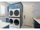 Bright laundry room, features blue cabinets, quartz countertops, and stacked washer/dryer at 5019 E Lucia Dr, Cave Creek, AZ 85331