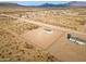 Aerial view of a house on a large lot with a chain link fence at 53929 W Bowlin Rd, Maricopa, AZ 85139