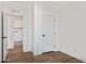 Bright bedroom with wood-look floors and access to another room at 53929 W Bowlin Rd, Maricopa, AZ 85139