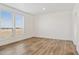 Bright bedroom with wood-look floors and two large windows at 53929 W Bowlin Rd, Maricopa, AZ 85139