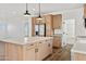 Kitchen island with light wood cabinets and quartz countertop at 53929 W Bowlin Rd, Maricopa, AZ 85139