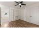 Bright bedroom with built-in shelves, wood-look floors, and ceiling fan at 6547 N 3Rd Ave, Phoenix, AZ 85013