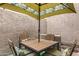 Private patio with seating for four under a patterned umbrella at 7858 E Glenrosa Ave, Scottsdale, AZ 85251