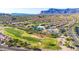 Aerial view of a golf course surrounded by houses and mountains at 8637 E Golden Cholla Cir, Gold Canyon, AZ 85118