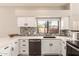 White kitchen with stainless steel appliances and marble countertops at 9428 W Taro Ln, Peoria, AZ 85382