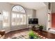 Living room features hardwood floors, large windows, and a flat-screen TV at 9428 W Taro Ln, Peoria, AZ 85382