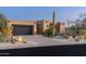 Stucco home with dark garage doors, stone accents, and drought-tolerant landscaping at 10585 E Crescent Moon Dr # 19, Scottsdale, AZ 85262