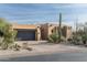 Stucco home with a dark garage door, stone accents, and desert landscaping at 10585 E Crescent Moon Dr # 19, Scottsdale, AZ 85262