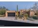 Desert landscape accents this stucco home with a dark garage door and stone accents at 10585 E Crescent Moon Dr # 19, Scottsdale, AZ 85262