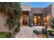 Elegant entry features a wrought-iron door, stonework, and a courtyard with mature plants at 10585 E Crescent Moon Dr # 19, Scottsdale, AZ 85262
