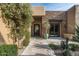 Elegant entry features a wrought iron door, stonework and a courtyard with mature plants at 10585 E Crescent Moon Dr # 19, Scottsdale, AZ 85262