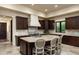 Gourmet kitchen with granite countertops, dark wood cabinets, and large island at 10585 E Crescent Moon Dr # 19, Scottsdale, AZ 85262