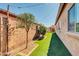 Landscaped backyard featuring a brick wall and faux grass with string lights overhead at 10851 E Sonrisa Ave, Mesa, AZ 85212