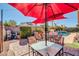 Outdoor dining area with seating and view of the sparkling swimming pool, covered by two large umbrellas at 10851 E Sonrisa Ave, Mesa, AZ 85212
