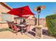Charming outdoor dining area with a stone column heater and a large sun umbrella at 10851 E Sonrisa Ave, Mesa, AZ 85212