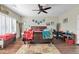 A primary bedroom featuring wood floors, ceiling fan, large bed, desk area, and bright natural light from window at 10851 E Sonrisa Ave, Mesa, AZ 85212