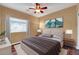 Well-lit bedroom showcasing a comfortable bed, ceiling fan, and ample natural light from the window at 10851 E Sonrisa Ave, Mesa, AZ 85212