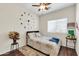 Inviting bedroom featuring hard surface flooring, a ceiling fan and a large decorative clock at 10851 E Sonrisa Ave, Mesa, AZ 85212