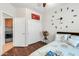 Charming bedroom showcasing laminated wood flooring, double closets, and an interesting clock display at 10851 E Sonrisa Ave, Mesa, AZ 85212