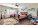 Primary bedroom with wood floors, ceiling fan, large bed, desk area, and bright natural light from window at 10851 E Sonrisa Ave, Mesa, AZ 85212