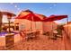 Outdoor patio boasts red umbrellas, stylish furniture, brick flooring, and festive string lights at 10851 E Sonrisa Ave, Mesa, AZ 85212