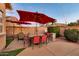 Cozy backyard patio with red umbrellas, a dining table and string lights, perfect for outdoor entertaining at 10851 E Sonrisa Ave, Mesa, AZ 85212
