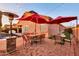 Outdoor patio boasts red umbrellas, stylish furniture, brick flooring, and festive string lights at 10851 E Sonrisa Ave, Mesa, AZ 85212