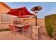 Outdoor dining area with an umbrella, stone heater and string lights creating a warm, inviting ambiance at 10851 E Sonrisa Ave, Mesa, AZ 85212