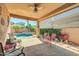 Inviting covered patio with ample seating, providing a relaxing view of the pool and landscaped backyard at 10851 E Sonrisa Ave, Mesa, AZ 85212