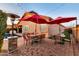 Charming patio featuring an outdoor dining table, stone heater, and string lights for cozy outdoor gatherings at 10851 E Sonrisa Ave, Mesa, AZ 85212