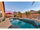 Landscaped backyard with a sparkling pool, a dining set, and ambient string lights at 10851 E Sonrisa Ave, Mesa, AZ 85212