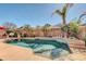 Sparkling swimming pool with waterfall feature, tropical palm trees, and elegant patio area under string lights at 10851 E Sonrisa Ave, Mesa, AZ 85212
