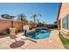 Inviting backyard pool with a basketball hoop, lush tropical landscaping, and stylish concrete patio under string lights at 10851 E Sonrisa Ave, Mesa, AZ 85212