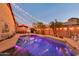 Exterior view of a backyard pool and patio area illuminated by charming string lights at dusk at 10851 E Sonrisa Ave, Mesa, AZ 85212