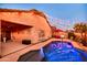 Exterior view of the pool area with a basketball hoop, seating area, and ambient string lights at 10851 E Sonrisa Ave, Mesa, AZ 85212