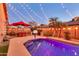 Backyard pool and patio area with ambient string lights, palm trees and seating area with a basketball hoop at 10851 E Sonrisa Ave, Mesa, AZ 85212