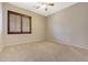 Neutral bedroom featuring carpeted floors, a ceiling fan, and window with wooden shutters at 15333 W Sells Dr, Goodyear, AZ 85395